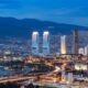 View of Izmir Turley from the sea in the afternoon, with city lights, buildings, and highways.